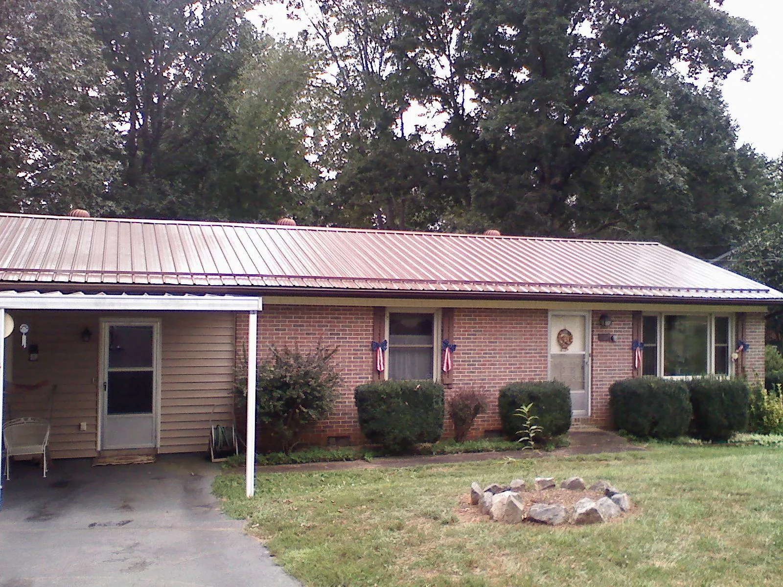 Bronze metal roof and carport on a brick ranch home — Roof Repair work by our crew in Horntown